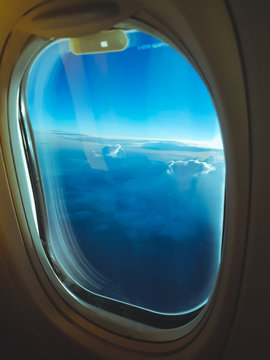 View from the plane window, turquoise blue clouds and sky during the morning flight