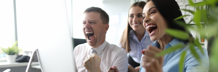 Portrait of beautiful businesslady and businessman holding fists. Wonderful businesswoman and guy winning tender and shouting with happiness. Business team concept