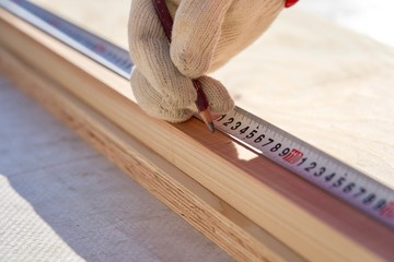 角材をメジャーで測る