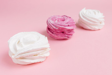 Fresh vanilla and berry marshmallows on a pastel pink background. The concept of home-cooked food, sweets. Minimalism, top view, flat lay, copyspace.