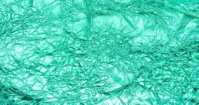 stop motion video footage with aluminium foil, crumpled and creased tinfoil of mint color and infinitely changing poster texture background with copy space