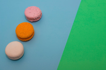 Three multi-colored macaroon on flat background