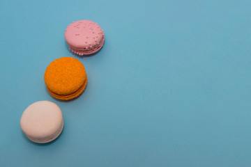Three multi-colored macaroon on flat background