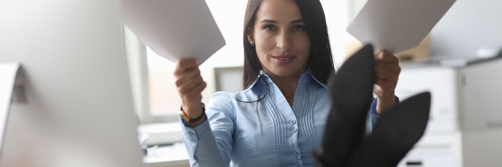 Portrait of smiling businesswoman showing important documents. Cute businesslady sitting on chair,...