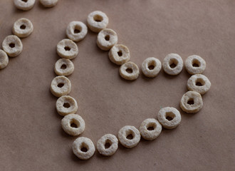 Heart concept made from round snacks on craft background