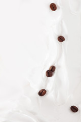 Obraz na płótnie Canvas Coffee milk dessert. Coffee beans among yogurt or milk.