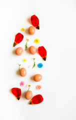 Easter pattern of Eggs with flowers petals and candies on the white background. Easter concept. Healthy feeding concept. 