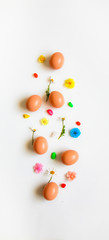 Easter pattern of Eggs with flowers petals and candies on the white background. Easter concept. Healthy feeding concept. 