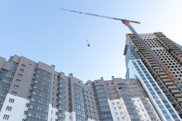 Fototapeta premium Multi-storey building, sunrise, construction crane, blue sky