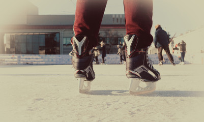 close-up hockey skates on a winter city rink