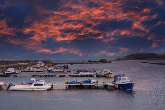 Small Boats in Maidens Harbour Near Girvan Scotland at a Dramatic Sunset Reflects on the Harbour.
