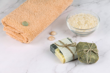 Soap, salt and a towel on a marble surface. Body care.