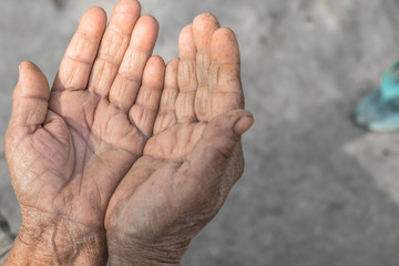 The old mother raises her hands for prayer