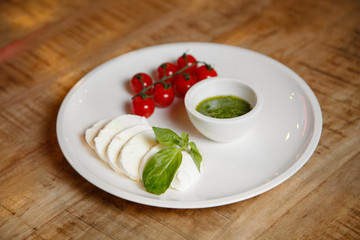 cheese and tomatoes with sauce on a white plate