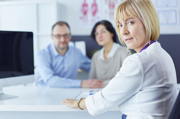 Doctor woman sitting with male patient at the desk