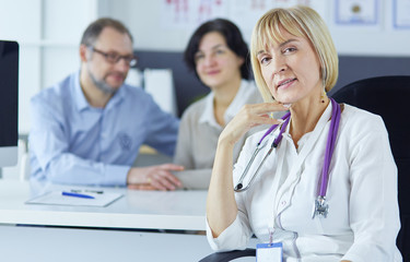 Obraz premium Doctor woman sitting with male patient at the desk
