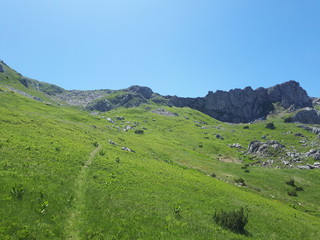 Fototapeta na wymiar Hiking trail on the mountain with rocks above it