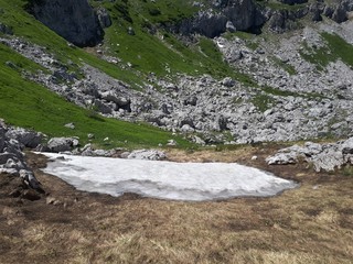 Small snow glacier in the mid summer period on mountain