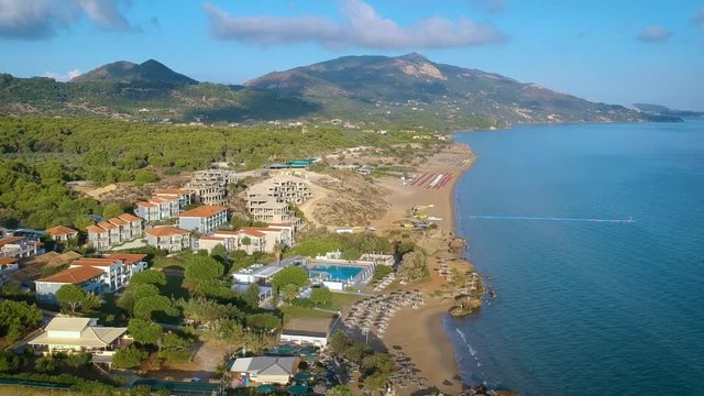 Birds eye view of the tourist destination of Zakynthos city surrounded by beautiful mountains on a bright sunny day. Aerial.