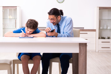 Obraz premium Busy father helping his son to prepare for exam