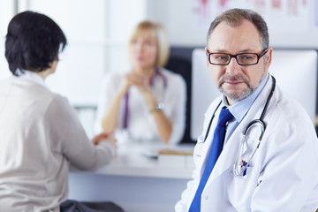 Portrait of senior doctor in office sitting at the desk