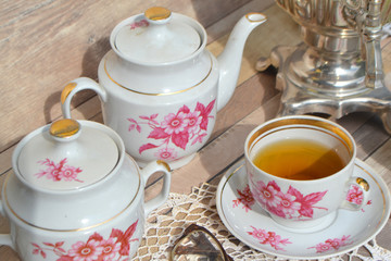 Obraz na płótnie Canvas romantic vintage cups of tea with hip roses on wooden table