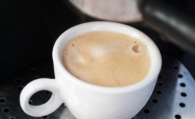 The coffee maker. Close shot. Coffee is poured from a coffee machine in the morning