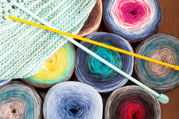 Background with woolen balls of various colors and knitting needle