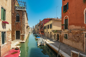 Fototapeta na wymiar VENICE, ITALY - August 03, 2019: Narrow pedestrian streets of Venice bitween the channels. Some quiet places almost without people