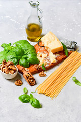 spaghetti pasta pesto Italy food. ingredients for traditional Italian pasta with pesto : spaghetti, fresh Basil, nuts, Parmesan cheese and olive oil. recipe Italian cuisine. selective focus