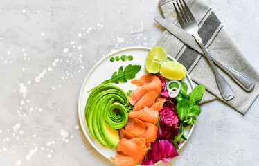 keto diet salmon and avocado salad with arugula and lime. on a white plate. healthy lunch. ketogenic diet  food 