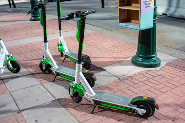 Scooter rental service on sidewalk in downtown - sharing economy