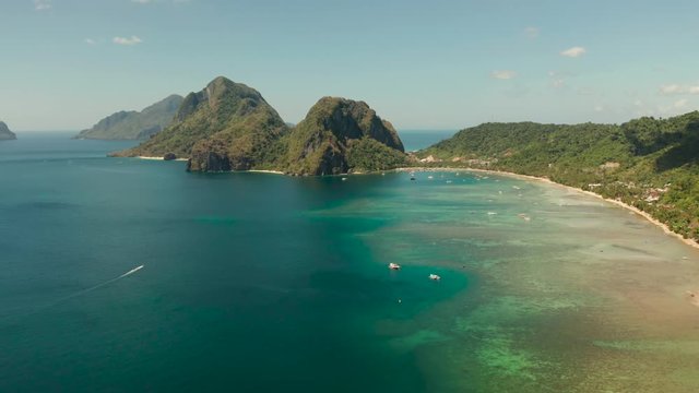 Aerial view bay with lagoon and turquoise water on a tropical island against the backdrop of the mountains. Corong corong beach, El Nido, Palawan, Philippines. Summer and travel vacation concept