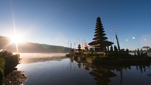 Timelapse: first rays of the sun are lightening the temple complex Pura Ulun Danu Beratan, at the edge of Lake Bratan. It is a a major Hindu Shaivite water temple on Bali, Indonesia. Morning