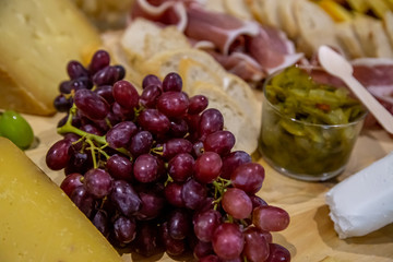 cheese and cold meat board with grapes and bread