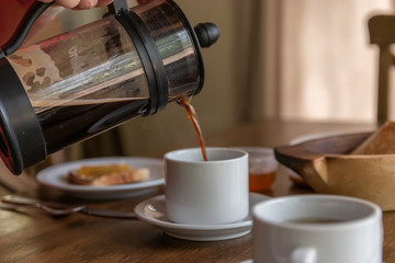 woman serving cup of hot coffee