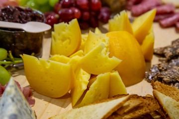 cheese and cold meat board with grapes and bread