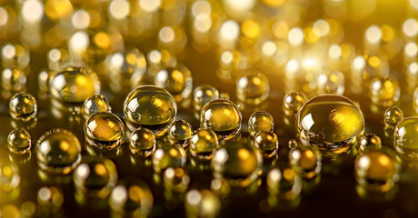 Gold shiny background with droplets, bubbles on black surface. Golden sparkle particles. Luxury abstract background.