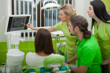 Dentist are treating teeth to client in dental office
