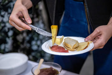 people cutting meat and cheese on wooden board