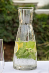 glass of water and bottle on wooden table