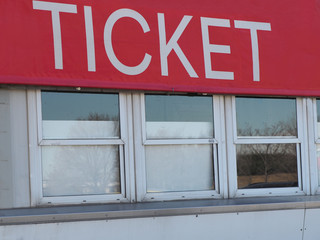 Obraz premium Closed ticket box office windows under big red sign