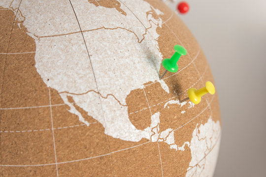 cork world ball showing USA and central america region with colored thumbtacks · especific view · plan destinations · visited places · colored thumbtacks marking places, Florida and Cuba