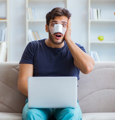 Young man recovering healing at home after plastic surgery nose