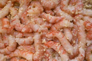 Shrimp tails in marinade. Tiger prawns marinated with garlic and olive oil. Mediterranean cuisine. Seafood with garlic in oil close up