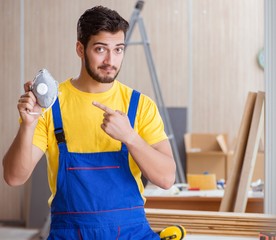 Young repairman carpenter working cutting wood