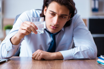 Sick male employee suffering in the office