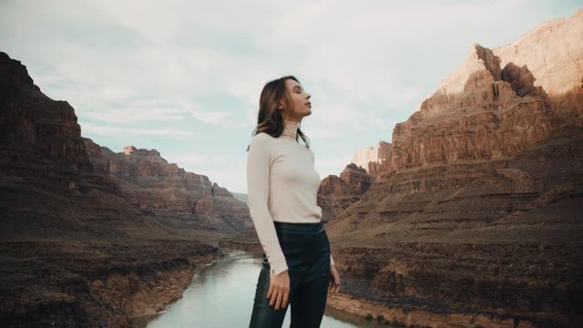 Traveler feels free in Grand Canyon in Arizona, looking round, enjoying power of nature, river between cliffs of canyon