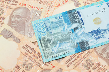 A blue five hundred tenge note from Kazakhstan with Indian ten rupee bank notes close up in macro
