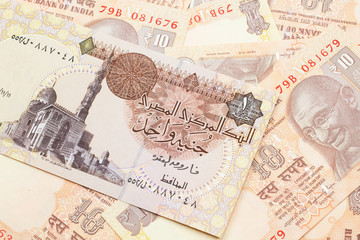 Obraz premium A close up image of an Egyptian one pound bank note with Indian ten rupee bank notes in macro